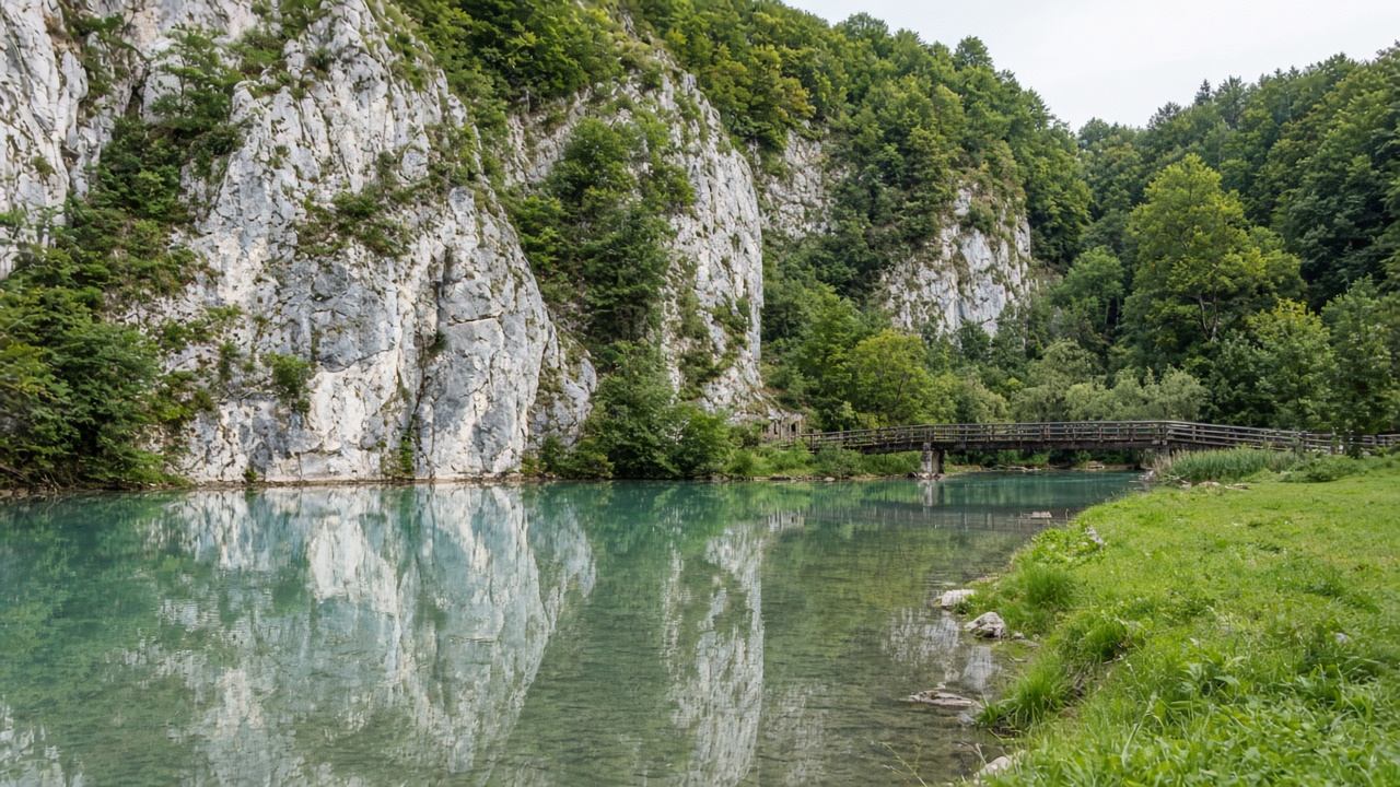 Ruhige Altmühl mit Spiegelung heller Felsen und Uferwiese